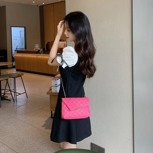 Pink quilted crossbody lady bag with elegant metal chain strap shown in cafe setting