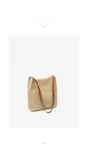 Détail du sac fourre-tout en paille tressée avec bandoulières en cuir marron