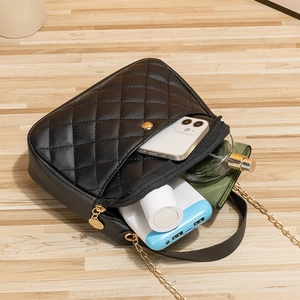 Quilted black chain crossbody bag with golden hardware showing interior storage capacity