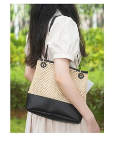 Outdoor shot of a woven tote bag with leather contrast and gold ring strap details