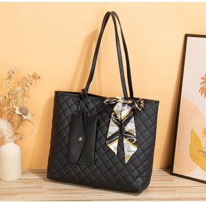 Détail du sac cabas matelassé noir avec pochette assortie et foulard en soie décoratif