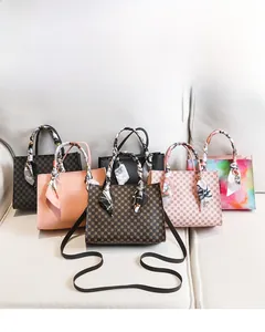 Multi-colored patterned handbags with silk scarf handles on a white sofa backdrop