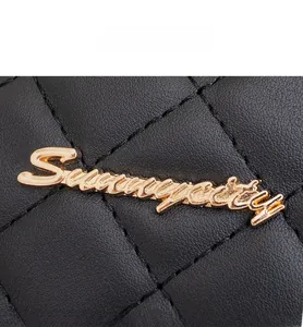 Close-up of golden Sunnycity metal logo on black quilted leather backpack surface