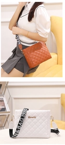 Detail of brown quilted crossbody bag with stylish wide logo strap and leather finish