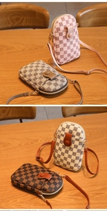 Macro shot of mini checkered crossbody bags with letter prints and long leather straps