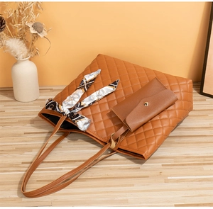 Détail du sac cabas en cuir matelassé avec anse en foulard de soie et petit ensemble
