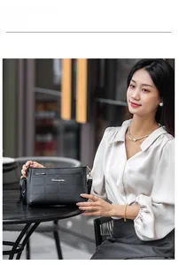 Classic black embossed shoulder bag with golden logo and textured square pattern