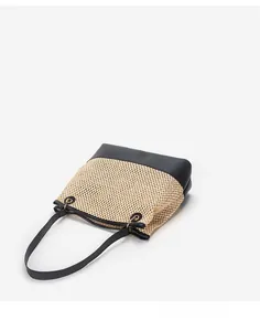 Close-up of the woven texture and black leather trim on a large capacity tote bag