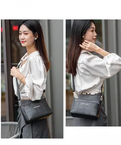 Quilted black leather crossbody bag featuring gold zipper details and metal logo on street