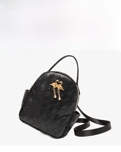 Detail of black woven leather backpack with a golden swan pendant and rhinestone accents