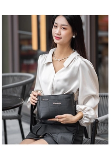Close-up of black quilted PU leather shoulder bag with gold logo and hardware