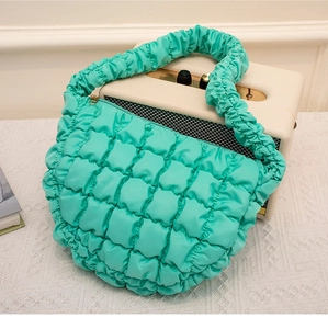 Detail der gerafften Griffe und Steppung der mintgrünen Cloud-Schultertasche