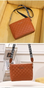 Detail of brown quilted PU leather crossbody bag with lettered wide fabric strap