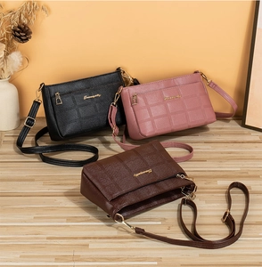 Detailed view of quilted faux leather crossbody bags with golden zippers and metal logos
