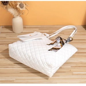 Détail du sac cabas matelassé blanc avec un foulard en soie décoratif sur l'anse