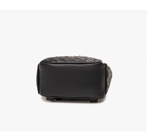 Detail view of woven leather texture and smooth bottom base of a black backpack
