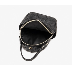 Detail view of large woven black leather backpack with spacious interior and metal zippers