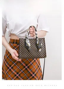 Detail of vintage monogram handbag with silk scarf handle wrap worn as a crossbody bag