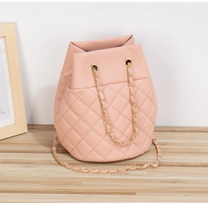 Gros plan détaillé du sac seau matelassé rose avec chaîne dorée et cordon de serrage