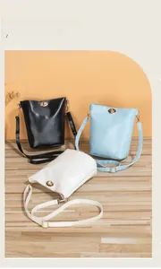 Trois sacs seaux minimalistes en noir, bleu clair et beige avec fermoirs métalliques