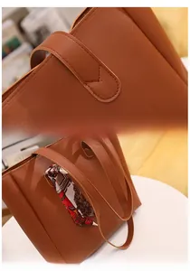 Detail of brown leather tote bag with stitch textures and decorative patterned scarf