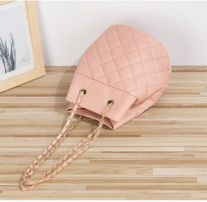 Détails du sac seau rose matelassé avec bandoulière en chaîne dorée et cordon de serrage