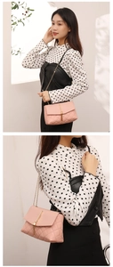 Détail du sac bandoulière matelassé rose avec pompon doré et bandoulière en chaîne dorée