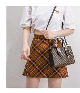 Detail of vintage patterned crossbody bag with silk scarf handle and metal clasp
