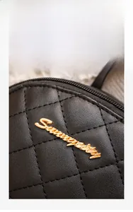 Détail du logo en métal doré et de la broderie matelassée sur le sac à dos noir