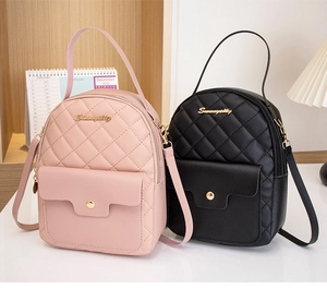 Detail of quilted mini backpacks in pink and black with elegant gold logo and chain straps