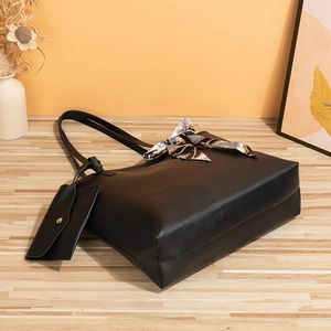 Grand sac cabas noir matelassé avec foulard en soie et pochette sur parquet