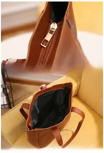 Close-up of zipper detail and spacious interior compartment of brown tote bag
