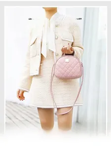 Detail of pink quilted handbag with round top handle and elegant crossbody strap