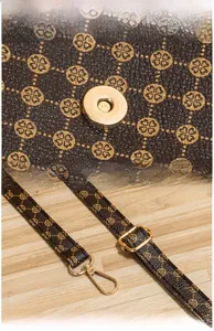 Dettaglio della fibbia dorata e della pelle stampata vintage sulla borsa a secchiello