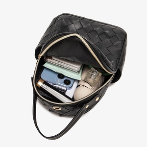Black woven leather backpack showing large interior capacity for essentials