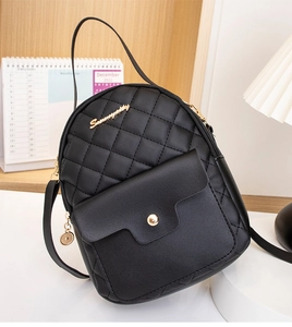 Detail of black quilted mini backpack with gold button pocket and elegant metal logo