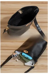 Détail du sac seau noir montrant la capacité de rangement pour téléphone et objets essentiels