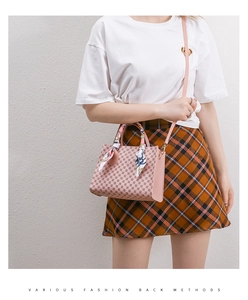 Detail view of pink printed handbag with decorative silk scarf handle on a fashion model