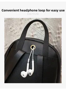 Détail d'un mini sac à dos en cuir noir avec port casque en métal doré à l'arrière