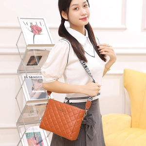 Quilted crossbody bag in orange PU leather with a stylish wide patterned strap