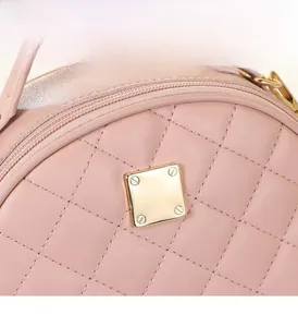 Detail of pink quilted leather handbag featuring a square golden metallic closure