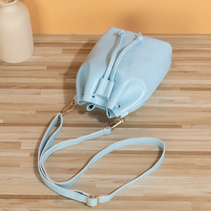 Minimalist light blue drawstring bucket bag in matte PU leather with adjustable strap