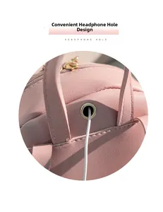 Close-up of pink leather mini backpack featuring a metal headphone hole and gold zipper