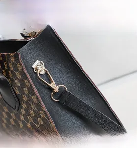 Detailed macro view of light gold swivel hooks and printed synthetic leather texture