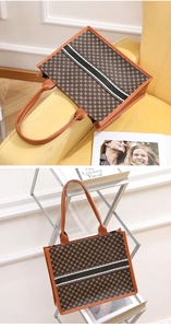Detail der Vintage-Monogramm-Tragetasche mit Kontraststreifen auf einem Samtsofa