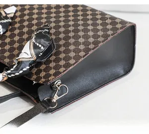Detailed view of the vintage monogram printed handbag with floral scarf handle and silver hardware