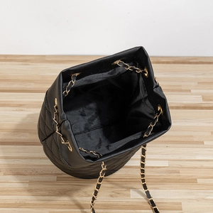 Sac seau matelassé noir élégant avec chaîne dorée présenté sous un angle de 45°