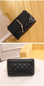 Détail du sac matelassé noir avec pompons dorés et poche plate à l'arrière