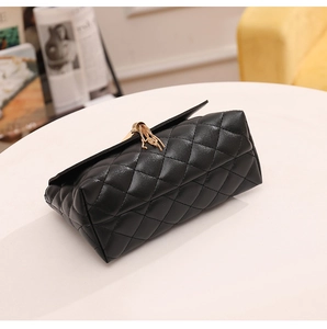 Détail du motif matelassé et du gland doré sur le sac à main en cuir noir élégant