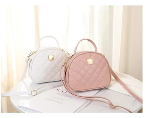 Detailed view of quilted faux leather handbags in white and pink on a marble table